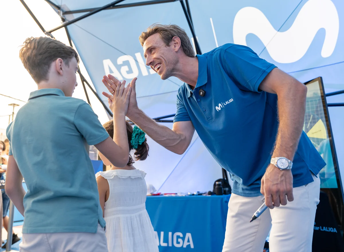 Nacho Monreal choca la mano con un niño en la activación de Málaga.
