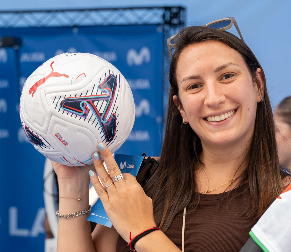 Una participante sonríe con un balón LALIGA recibido en la activación de Málaga.